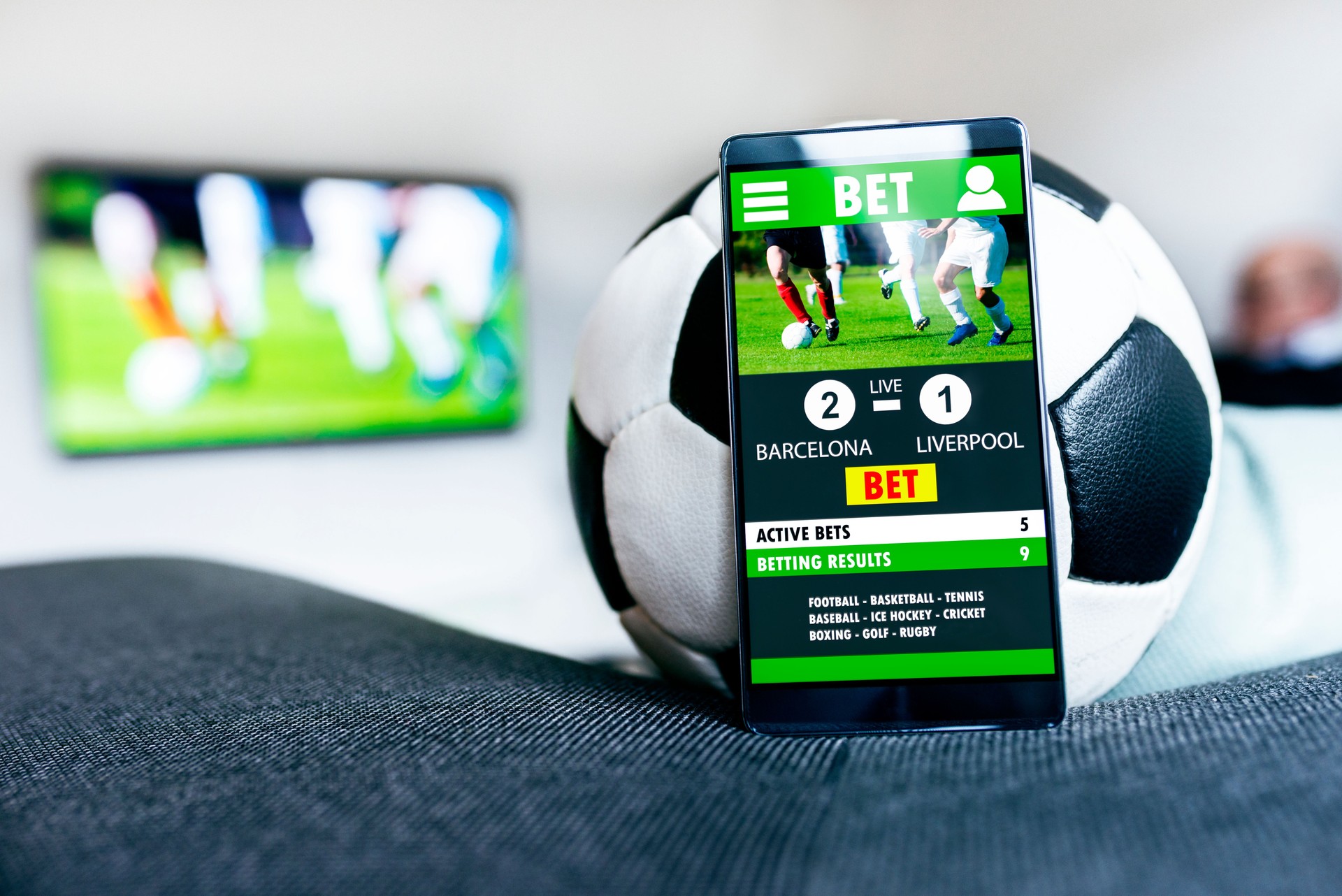 Soccer ball and mobile phone with betting app side by side